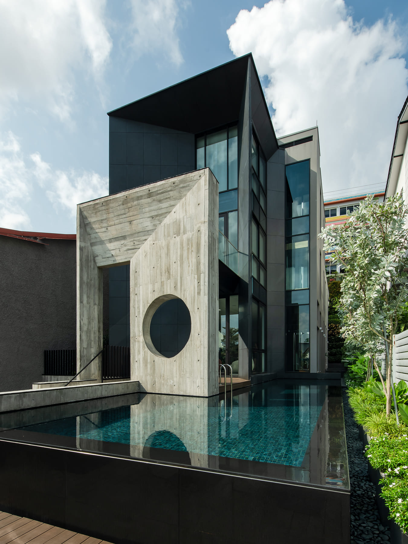 Brutalist architecture featuring raw concrete facade in a modern tropical home